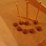 Carefully slide our pretzel sticks into the pilot holes. We don't want to break the PB Minis or the pretzel sticks.
